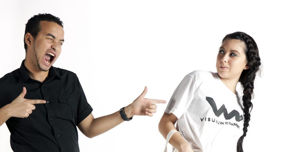 muž v černé košili ukazuje na ženu v triku