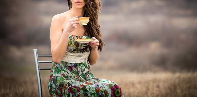 žena sedí na židli na louce